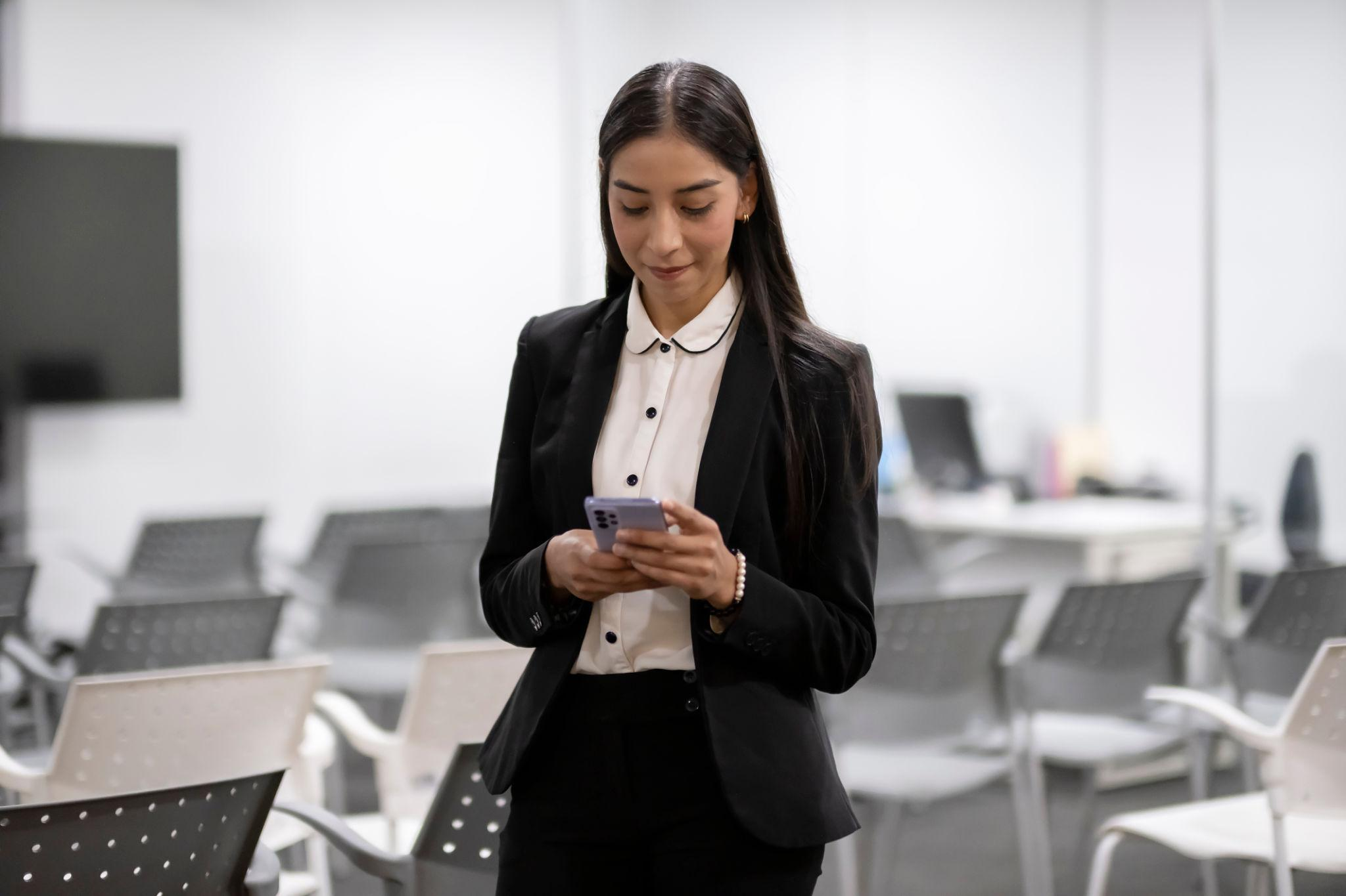 Property manager checking her phone in an office